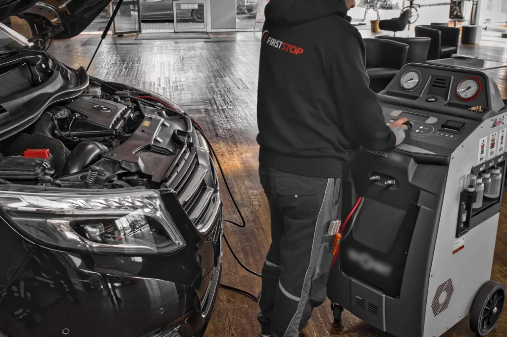 Fahrzeug vorne sichtbar + geöffnete Motorhaube + Kühlflüssigkeit-Service + Werkstattkontext bei FIRSTSTOP Schwerin.
